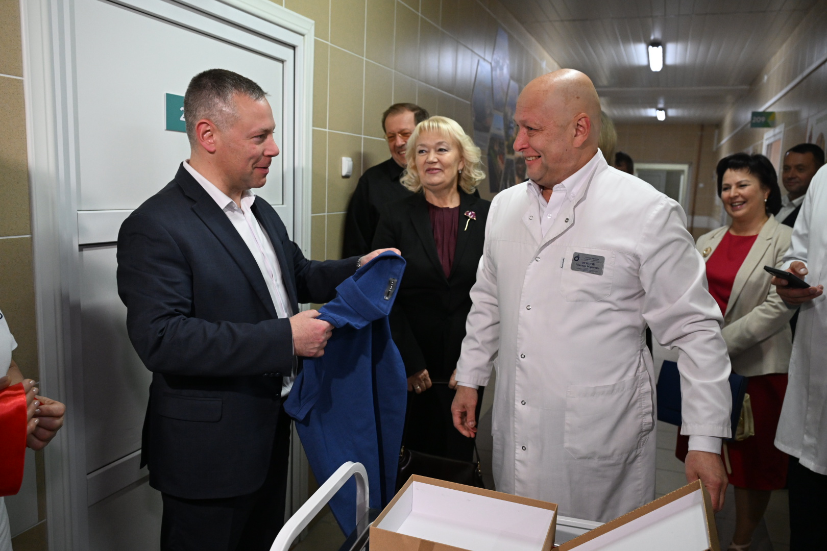 Врач в белом халате и гости на открытии центра мини-инвазивных технологий в больнице