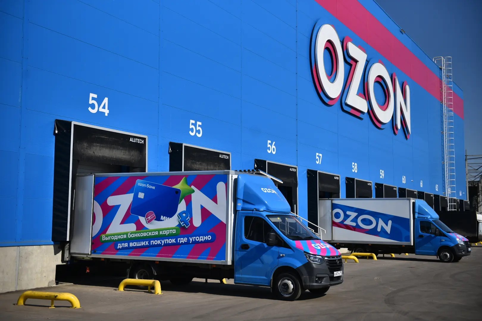 Грузовые автомобили Ozon у складских ворот логистического комплекса