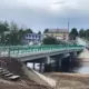Мост через реку Юхоть в Большом Селе с зелёными перилами и пешеходной лестницей