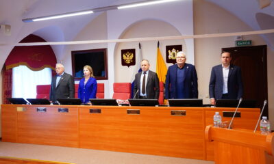 Депутаты областной думы стоят в зале заседаний во время минуты молчания