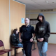 Сотрудник полиции сопровождает мужчину в капюшоне по коридору суда