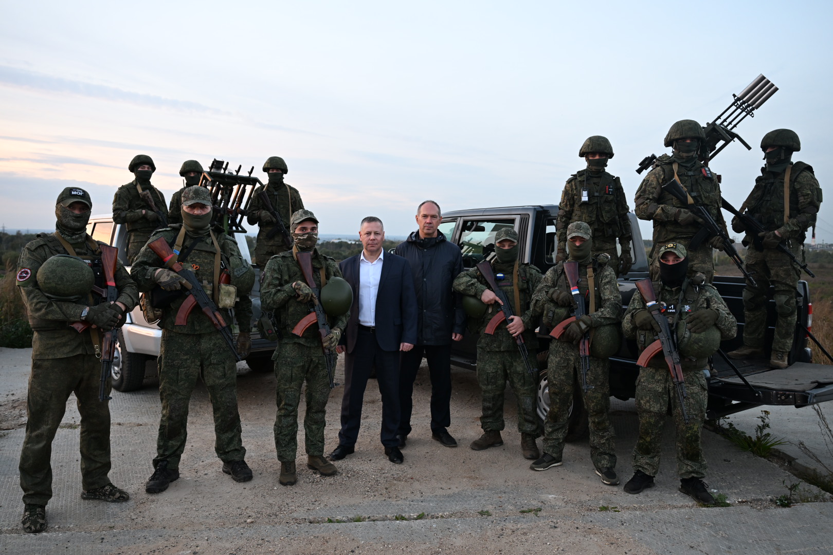 Вооружённые военнослужащие в масках и двое мужчин у пикапа