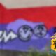 Размытое граффити на красно-фиолетовой стене с эмблемой МВД России