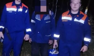 Сотрудники МЧС рядом со спасённым человеком в ночном лесу
