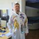 Врач в белом халате с детскими рисунками драконов в больничном кабинете