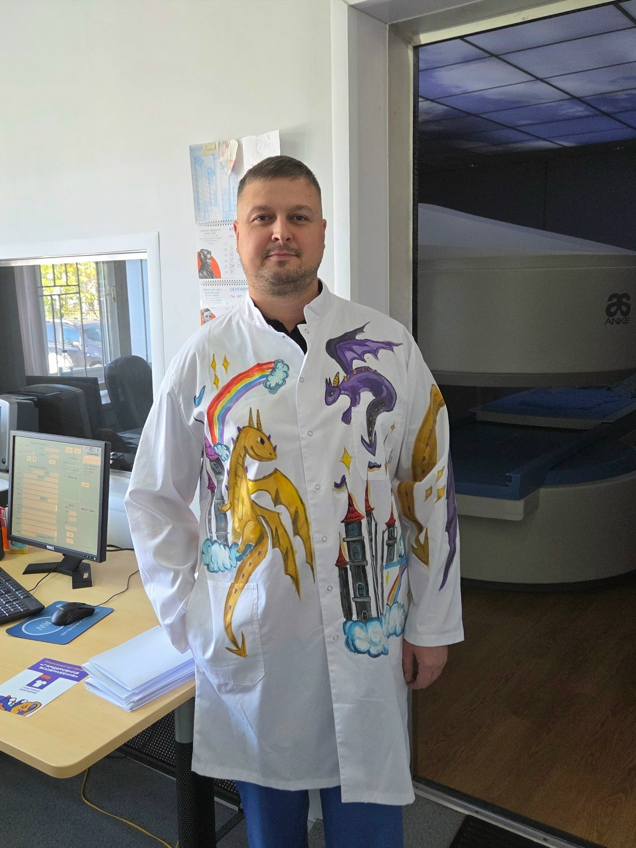 Врач в белом халате с детскими рисунками драконов в больничном кабинете