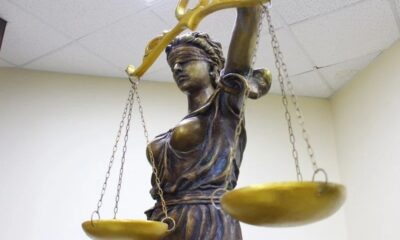 Статуя Фемиды с завязанными глазами и золотыми весами в помещении
