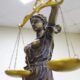 Статуя Фемиды с завязанными глазами и золотыми весами в помещении