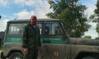 Сотрудник лесного надзора в камуфляже стоит у служебного внедорожника