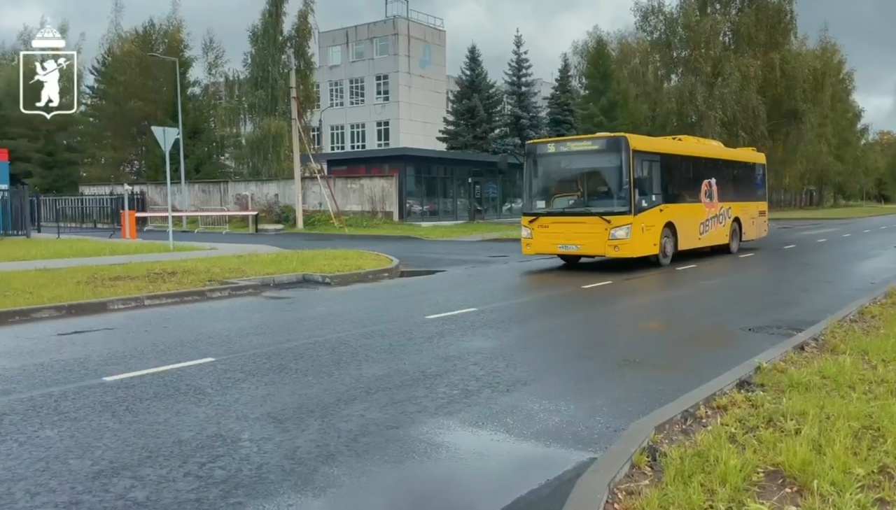 Жёлтый городской автобус едет по мокрой отремонтированной улице в Ярославле