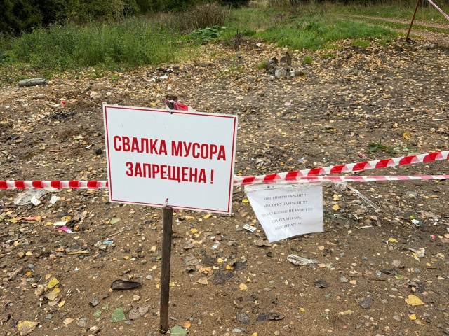 Табличка «Свалка мусора запрещена» на огороженном участке с разбросанным мусором