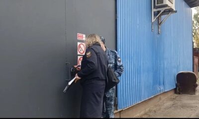 Сотрудники службы у опечатанной двери овощной базы в Ярославле