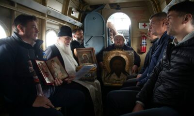 Священник с иконами и участники крестного облета в салоне вертолета