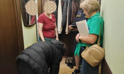 Судебные приставы и женщина в прихожей квартиры во время проверки
