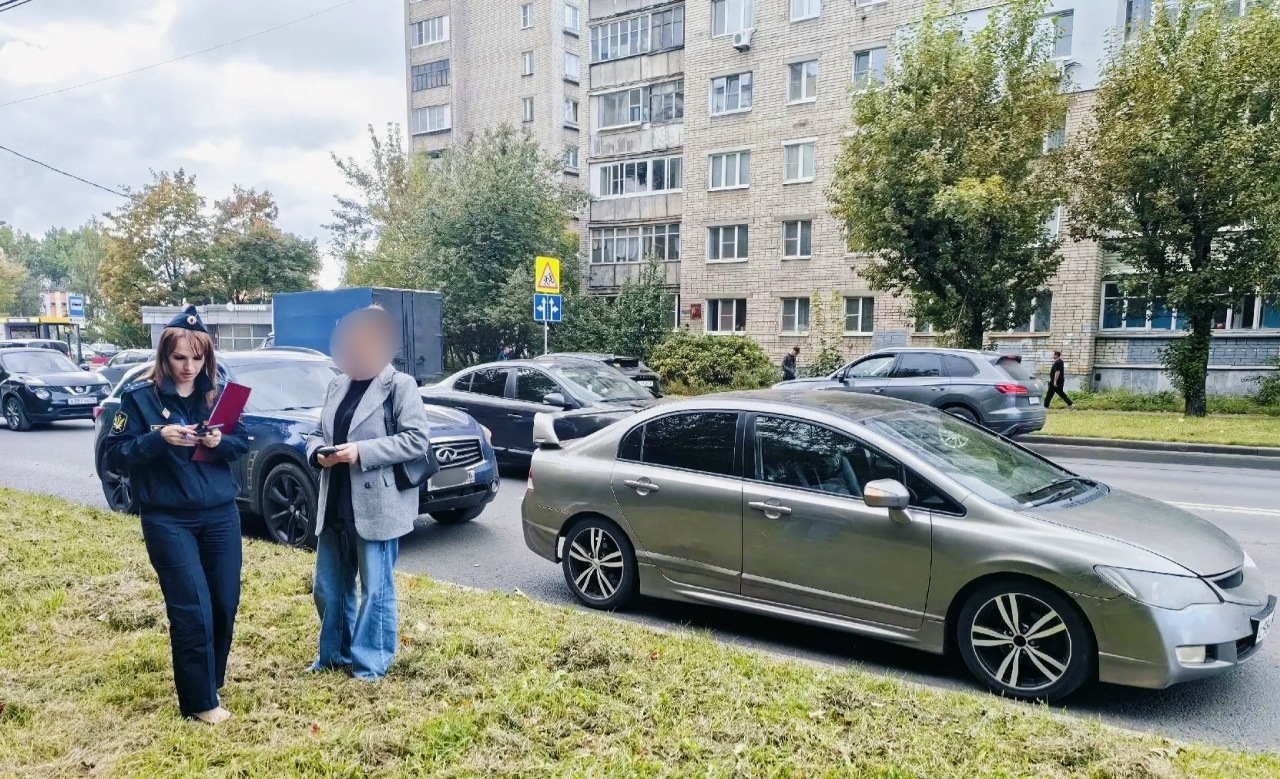Судебный пристав оформляет документы у автомобиля на городской улице