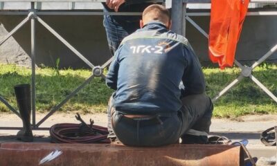 Рабочий ремонтирует теплосети у траншеи