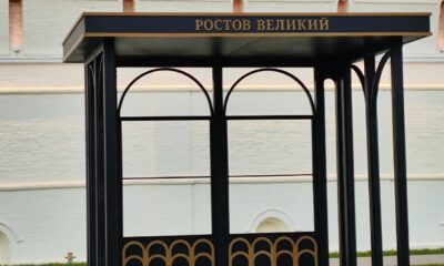 Чёрная остановка с надписью «Ростов Великий» у белой стены кремля