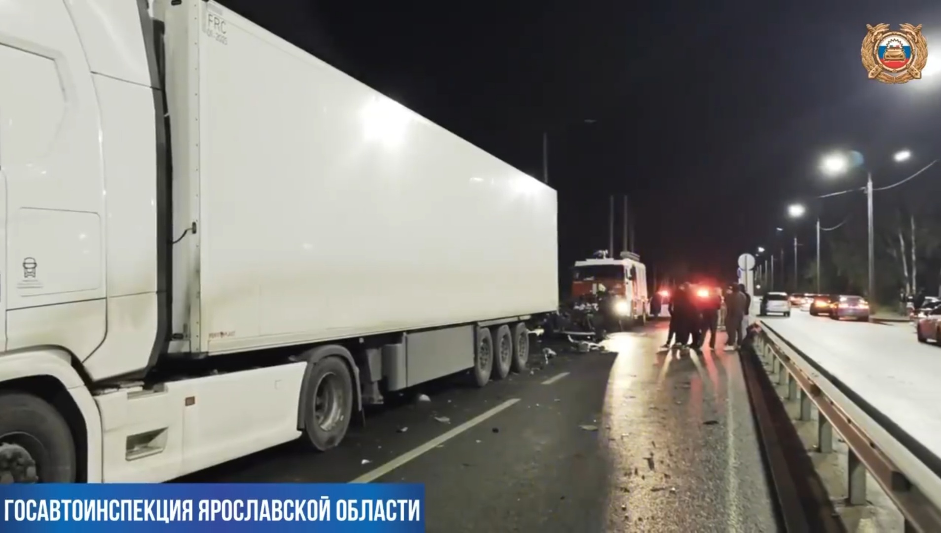 Грузовик и спецтехника на месте ночного ДТП на освещённой дороге