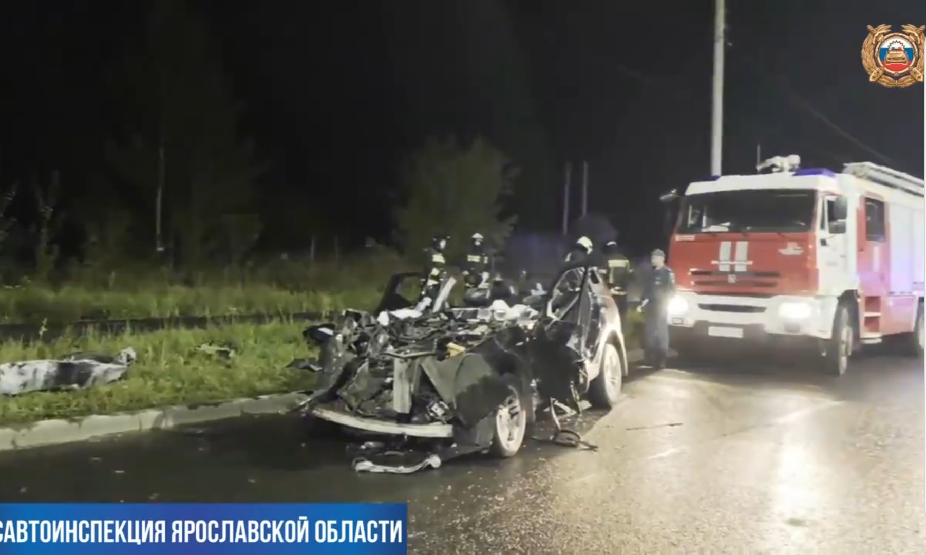 Разбитый автомобиль после ДТП на ночной дороге рядом с пожарной машиной