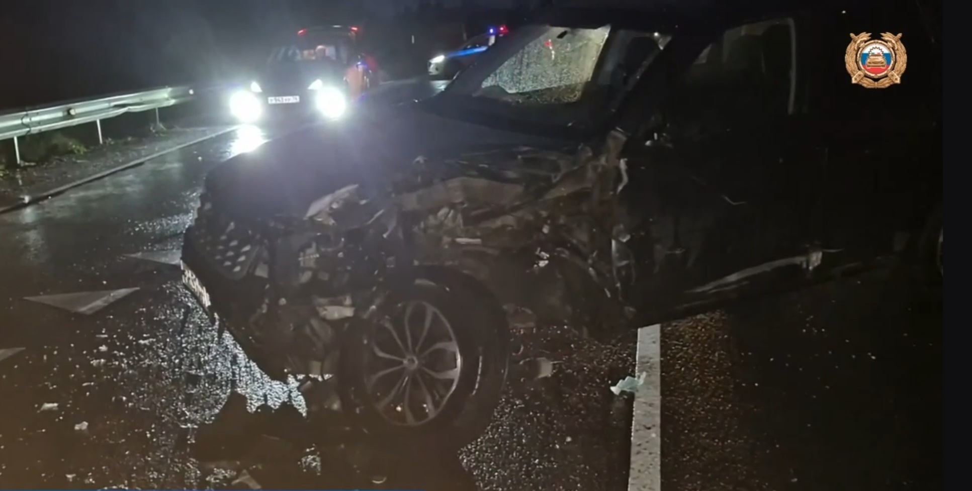 Разбитый автомобиль после ДТП на мокрой ночной дороге