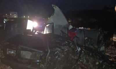 Сильно повреждённый автомобиль после ДТП ночью, освещённый фарами