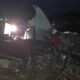 Сильно повреждённый автомобиль после ДТП ночью, освещённый фарами