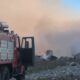 Пожарная машина МЧС у горящих обломков и густого дыма