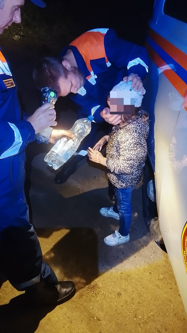 Спасатели оказывают помощь ребёнку возле автомобиля ночью