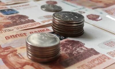 Стопки российских монет на пятитысячных рублёвых купюрах
