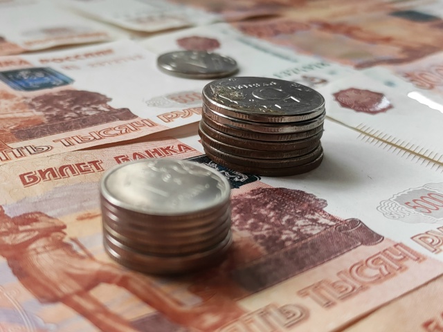 Стопки российских монет на пятитысячных рублёвых купюрах