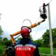 Энергетик Россети наблюдает за работой коллеги на автовышке у опоры линии электропередачи