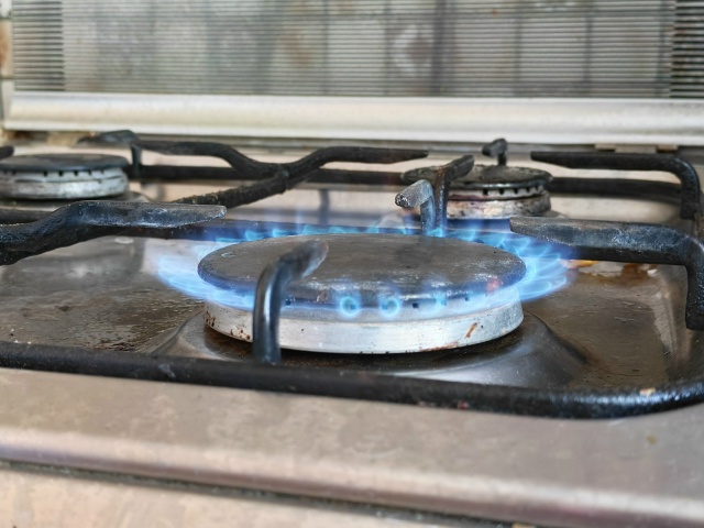 Горящая конфорка газовой плиты с голубым пламенем