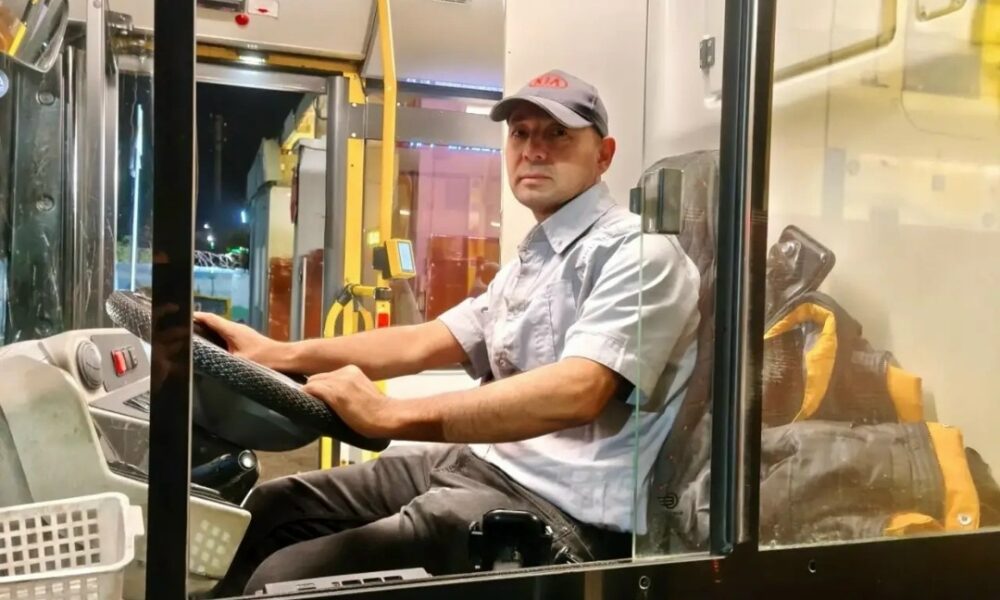 Водитель автобуса в кабине за рулём