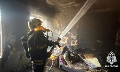 Сотрудник МЧС тушит пожар в выгоревшей квартире