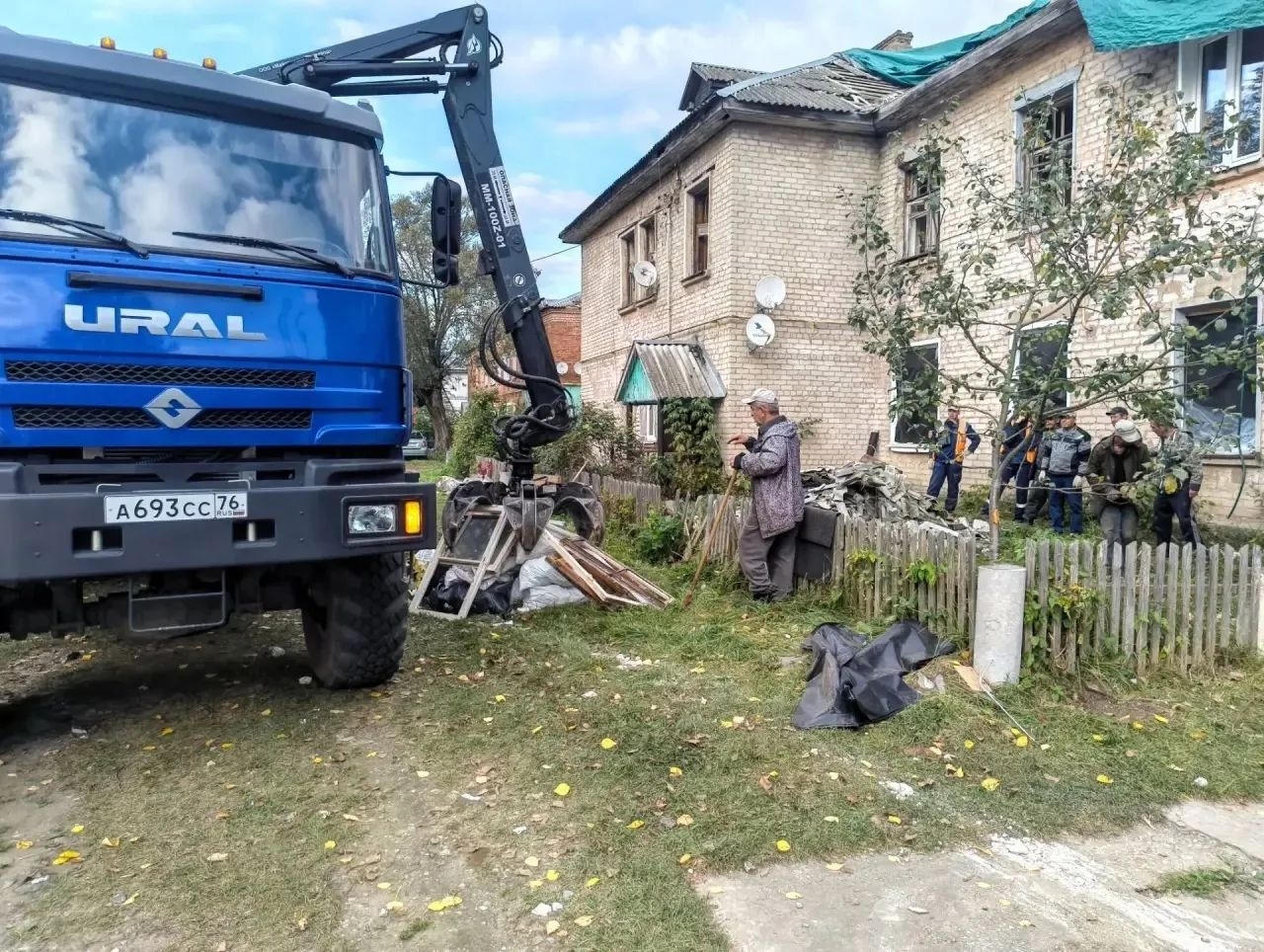 Грузовик с манипулятором и спасатели у жилого дома в Кубринске