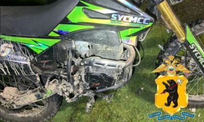 Зелёный питбайк SYCMCC с грязными колёсами на траве
