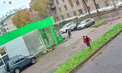 Кадр с камеры наблюдения: два человека у здания и припаркованных автомобилей