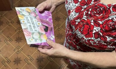 Женщина держит подарочную коробку с открыткой ко дню доброты и уважения