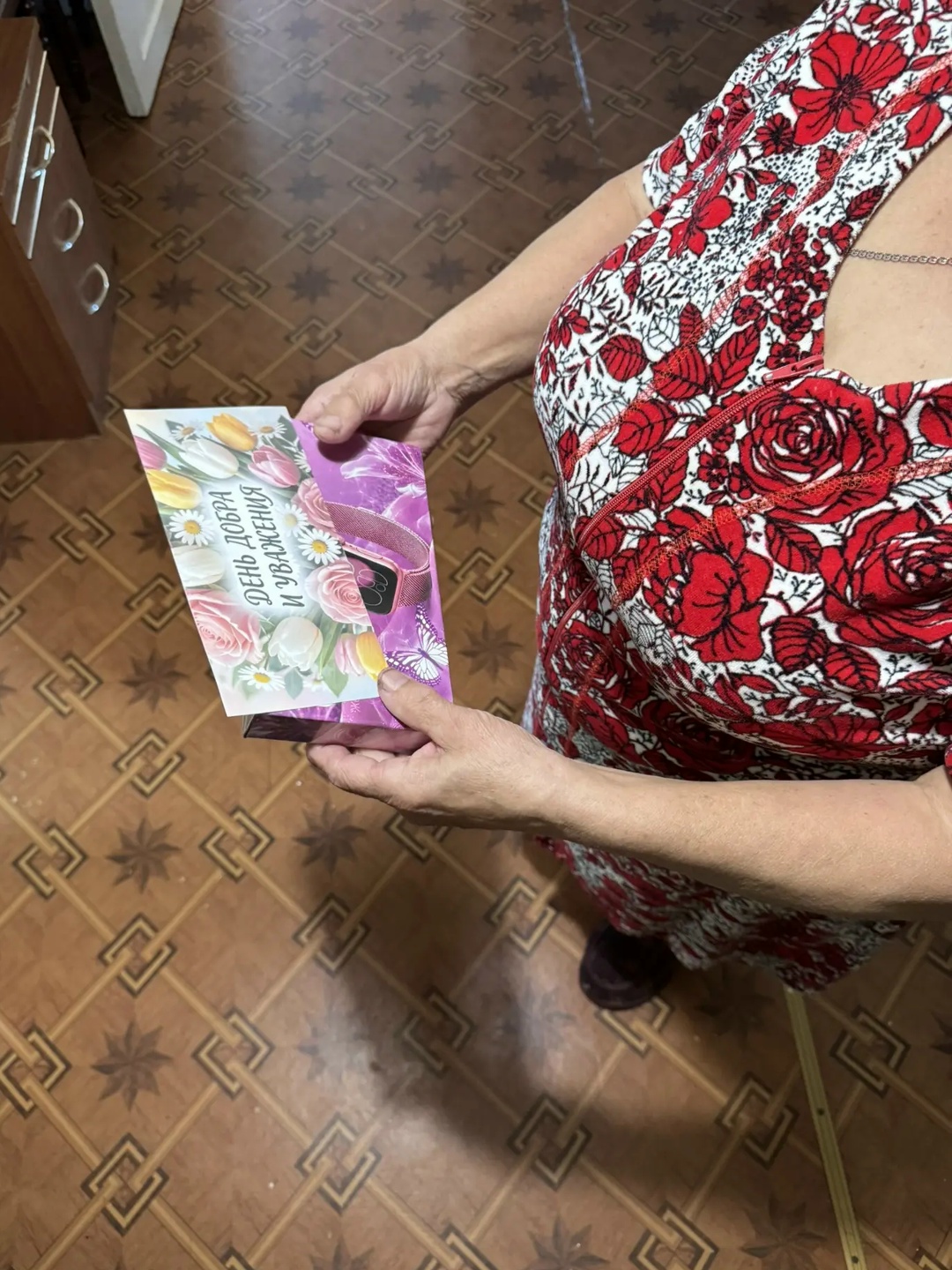 Женщина держит подарочную коробку с открыткой ко дню доброты и уважения