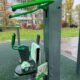 Уличный тренажёр на спортивной площадке с тряпками и ведром для уборки