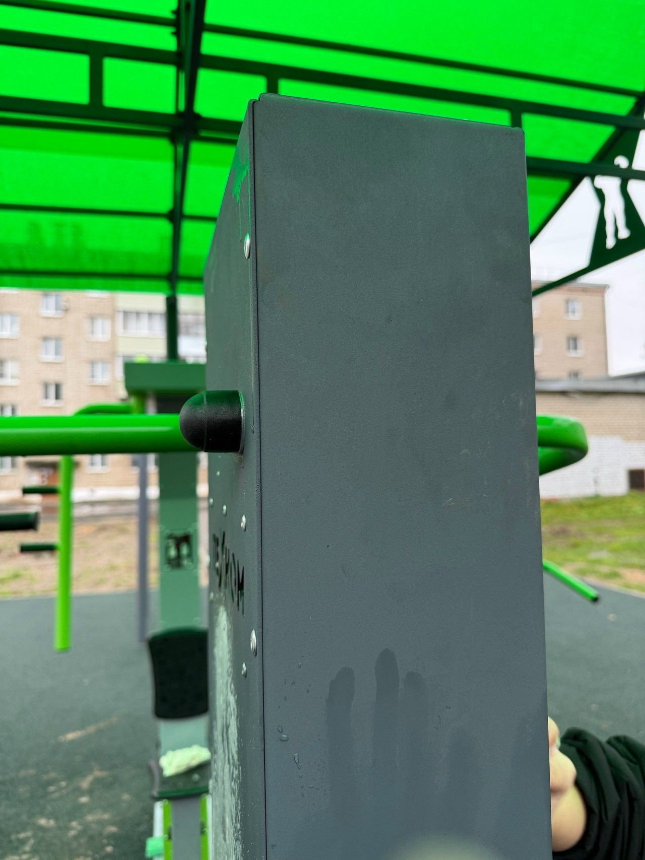 Школьник оттирает следы краски с тренажёра на спортивной площадке