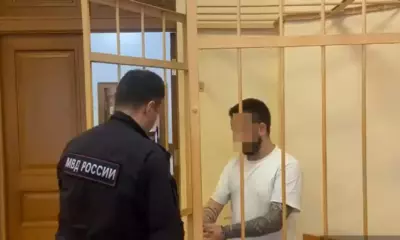 Подсудимый в клетке разговаривает с сотрудником МВД России в суде