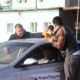 Таксист и мужчины ставят стаканы с водой на крышу автомобиля