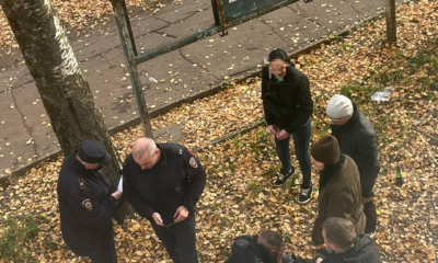 Полицейские задерживают мужчину у автобусной остановки среди осенней листвы