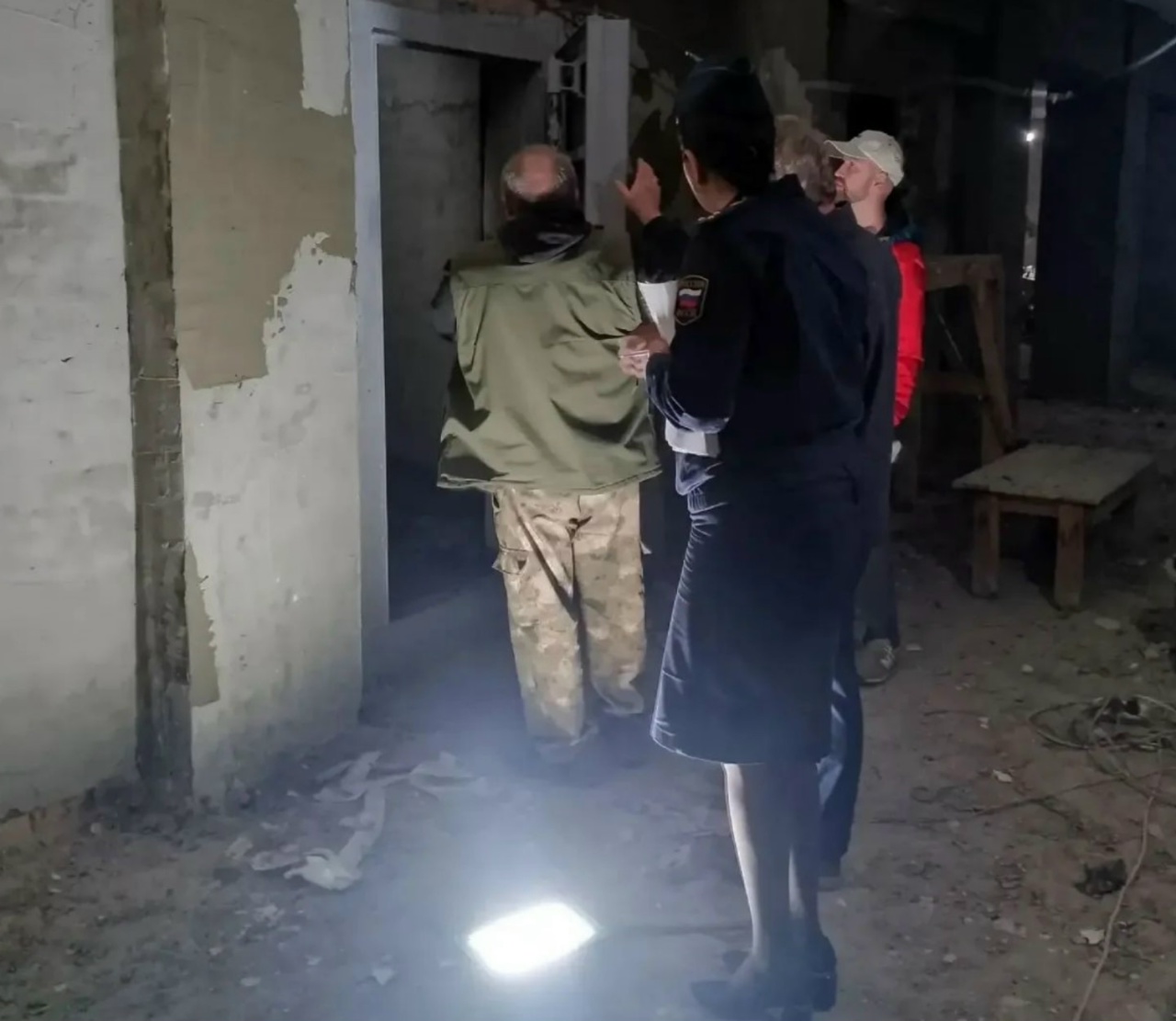 Приставы осматривают бомбоубежище с обвалившейся штукатуркой и строительным мусором