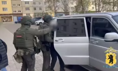 Сотрудники полиции задерживают мужчину у автомобиля во дворе жилого дома