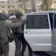 Сотрудники полиции задерживают мужчину у автомобиля во дворе жилого дома