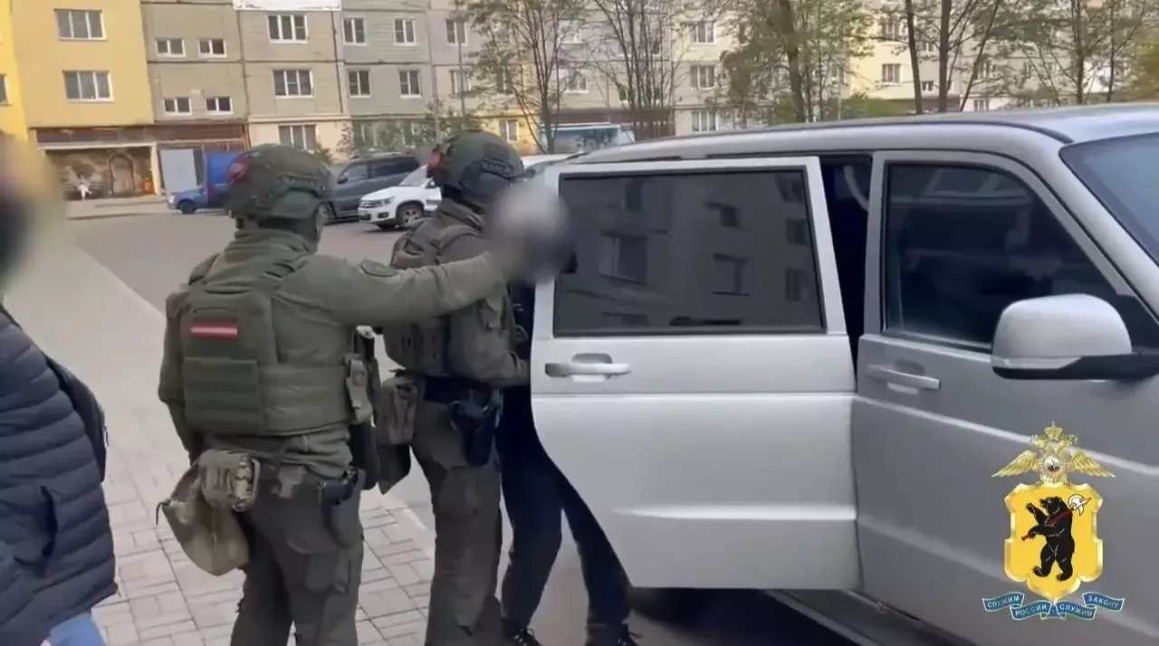 Сотрудники полиции задерживают мужчину у автомобиля во дворе жилого дома