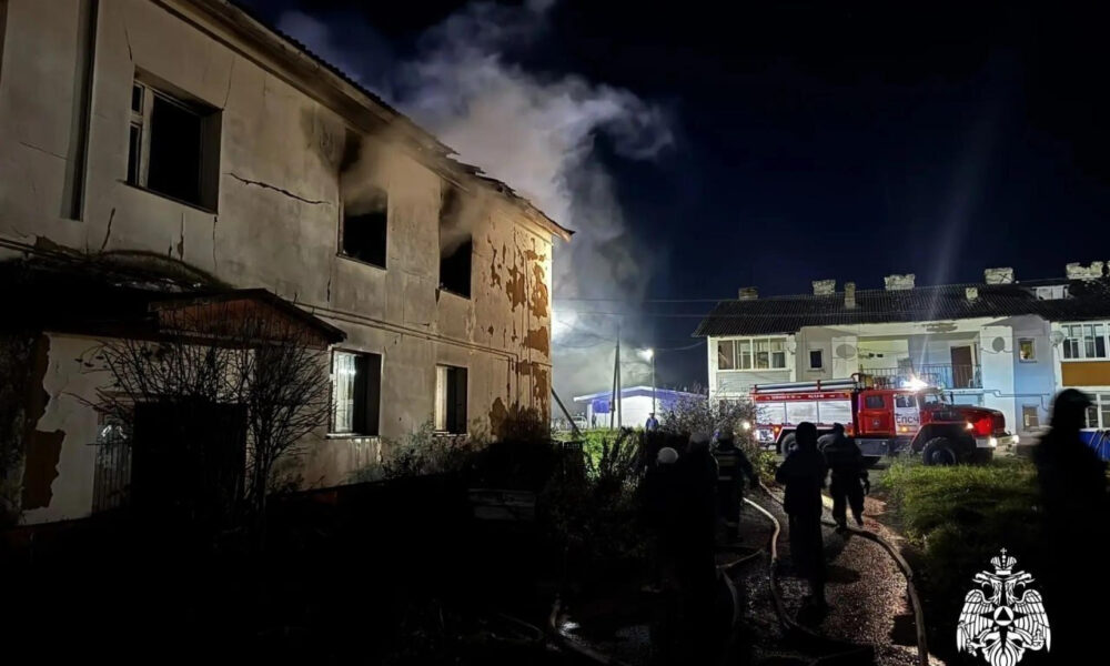 Ночной пожар в бывшем Доме ветеранов: дым, пожарная машина и люди у повреждённого здания