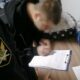 Судебный пристав оформляет документы с подростком за столом
